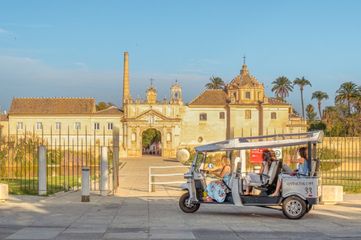 a person riding a horse drawn carriage in front of a building