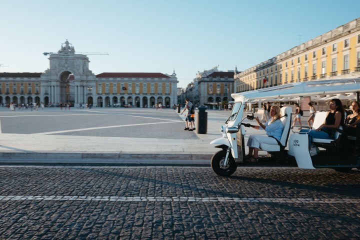 a person sitting on a motorcycle in front of a building