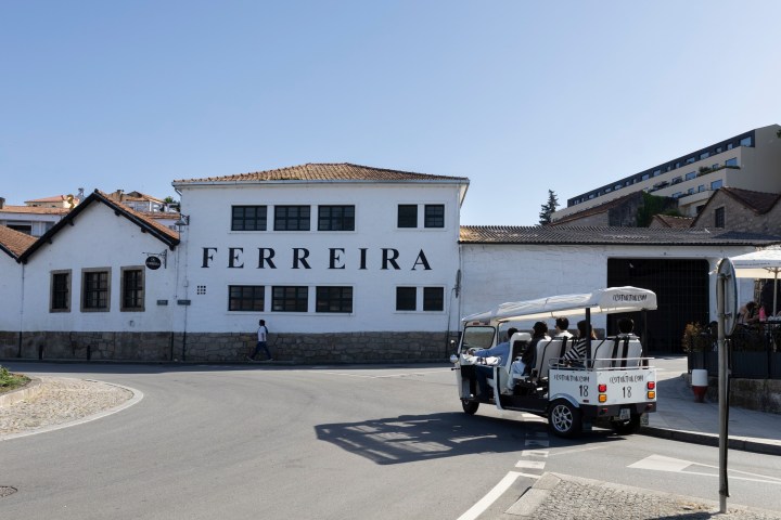 White building with 'FERREIRA' text and a tour vehicle in front.