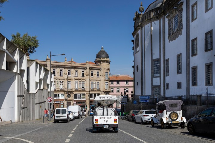 Street in Porto with vintage cars and historic architecture.